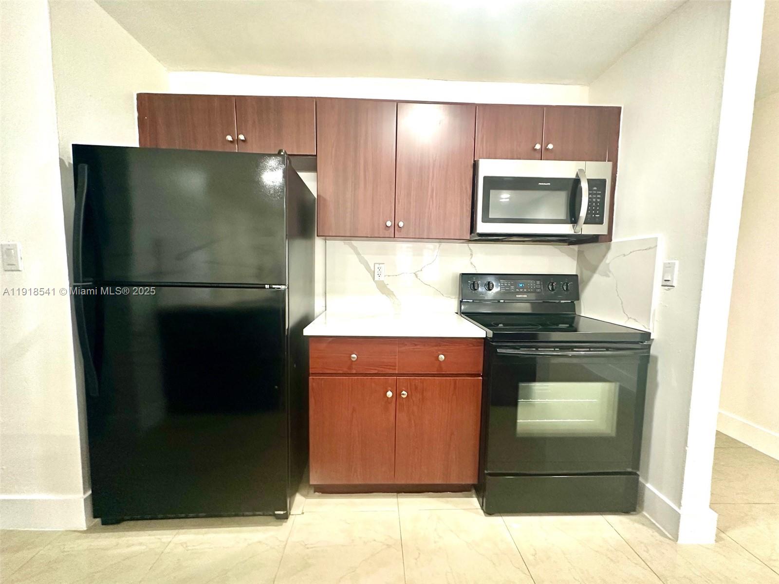 3947 Northwest 207 St Road Miami Gardens, FL 33055 - Photo 9 of 23 a kitchen with a refrigerator and a stove