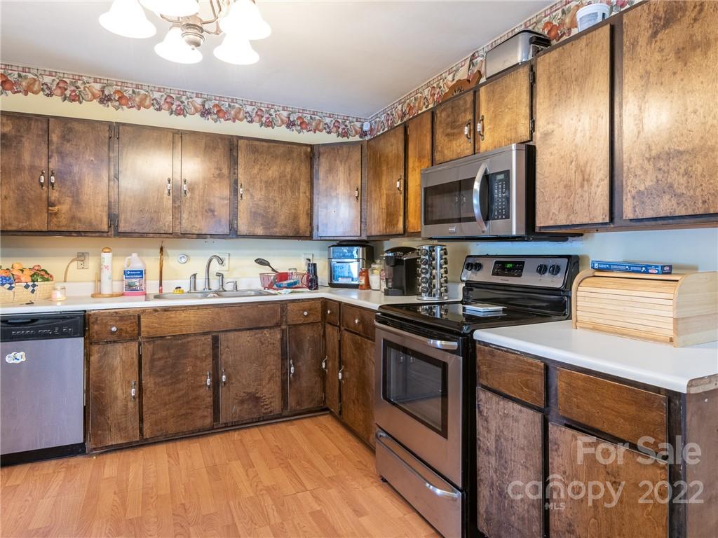 162 Alex Road Cleveland, NC 27013 - Photo 12 of 30 a kitchen with stainless steel appliances granite countertop a stove a sink dishwasher and a microwave oven with large wooden cabinets