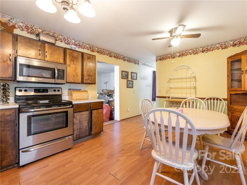 162 Alex Road Cleveland, NC 27013 - Photo 13 of 30 a kitchen with stainless steel appliances a stove a sink dishwasher a dining table and chairs with wooden floor