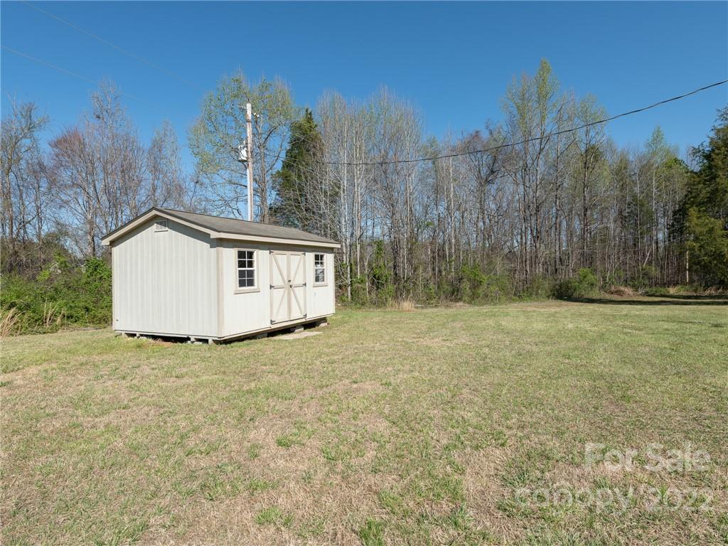 162 Alex Road Cleveland, NC 27013 - Photo 24 of 30 a view of a house with a dry yard and a large tree