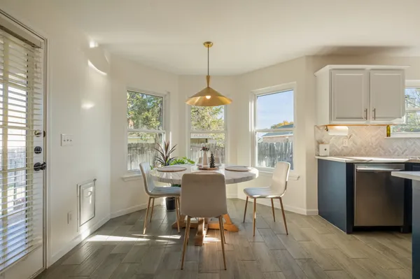 a dining room with furniture a chandelier and wooden floor