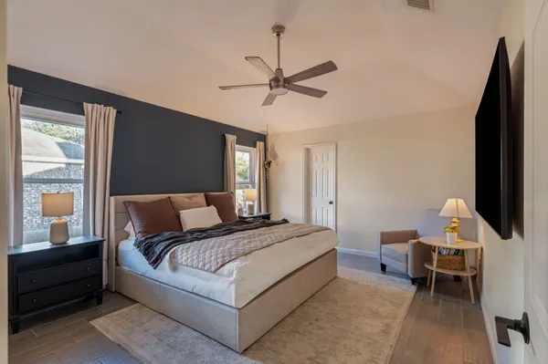 a bedroom with a bed wooden floor and window