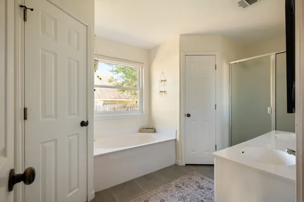a bathroom with a tub a sink and a window