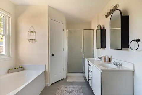 a bathroom with a tub sink and mirror
