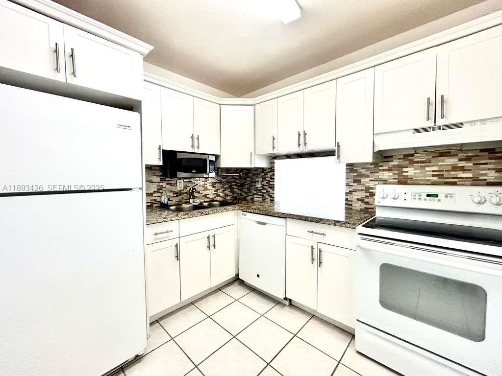 a kitchen with cabinets appliances and a sink