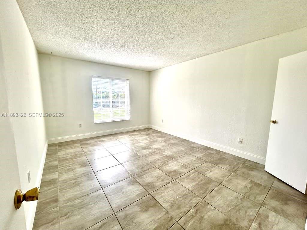 4920 Northwest 79th Avenue, Unit 307 Doral, FL 33166 - Photo 15 of 21 a view of an empty room and window