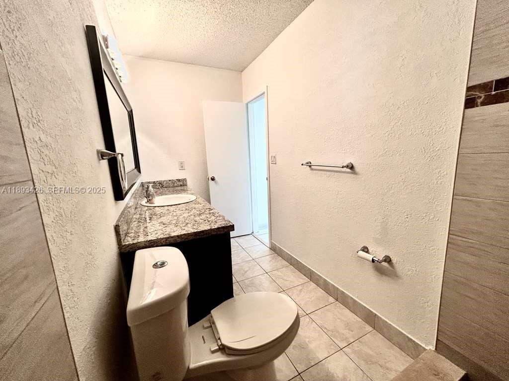 4920 Northwest 79th Avenue, Unit 307 Doral, FL 33166 - Photo 21 of 21 a bathroom with a sink a toilet a mirror and shower