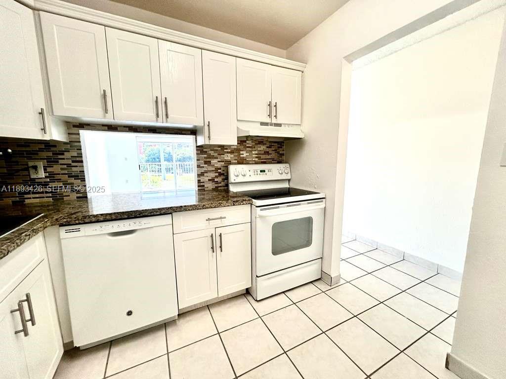 4920 Northwest 79th Avenue, Unit 307 Doral, FL 33166 - Photo 4 of 21 a kitchen with white cabinets and white appliances