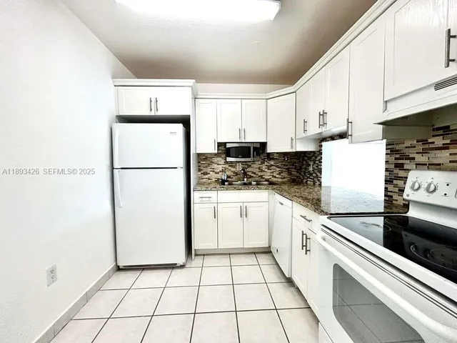 a kitchen with a refrigerator sink stove and cabinets