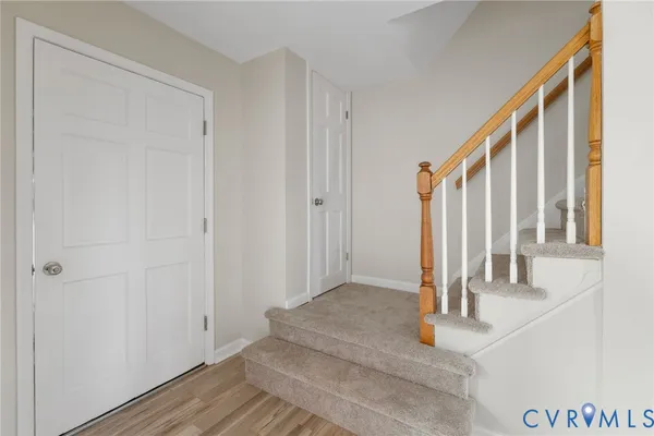 a view of a hallway with wooden floor and staircase