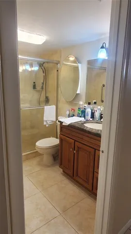 a bathroom with a double vanity sink toilet mirror and shower