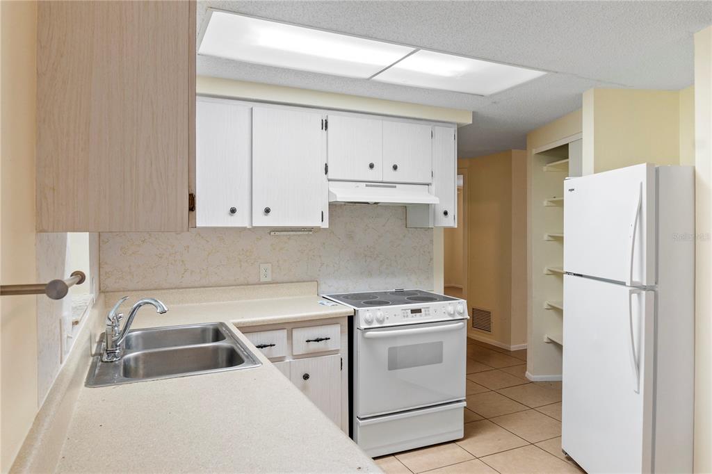 340 Periwinkle Road Venice, FL 34293 - Photo 14 of 36 a kitchen with a white sink a stove and refrigerator