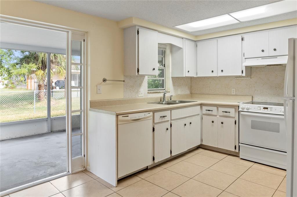 340 Periwinkle Road Venice, FL 34293 - Photo 15 of 36 a kitchen with white cabinets and white appliances