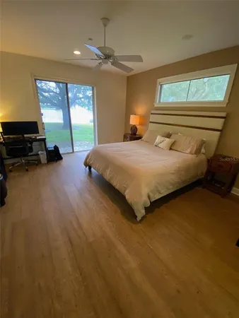 a bedroom with a bed and large windows