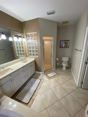 a spacious bathroom with a double vanity sink toilet and a shower