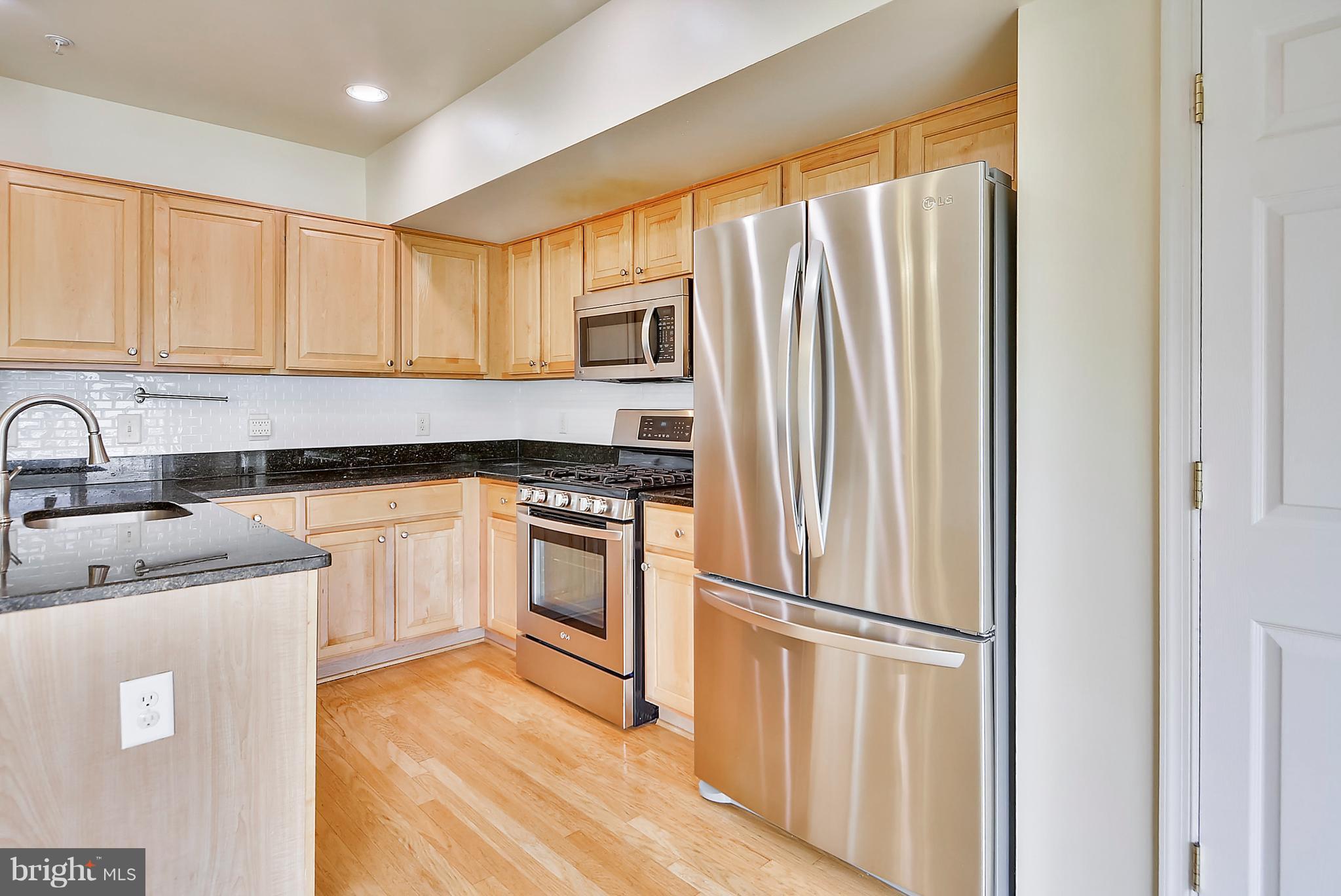 11357 King George Drive, Unit 10 Wheaton, MD 20902 - Photo 11 of 30 a kitchen with a refrigerator sink and stove