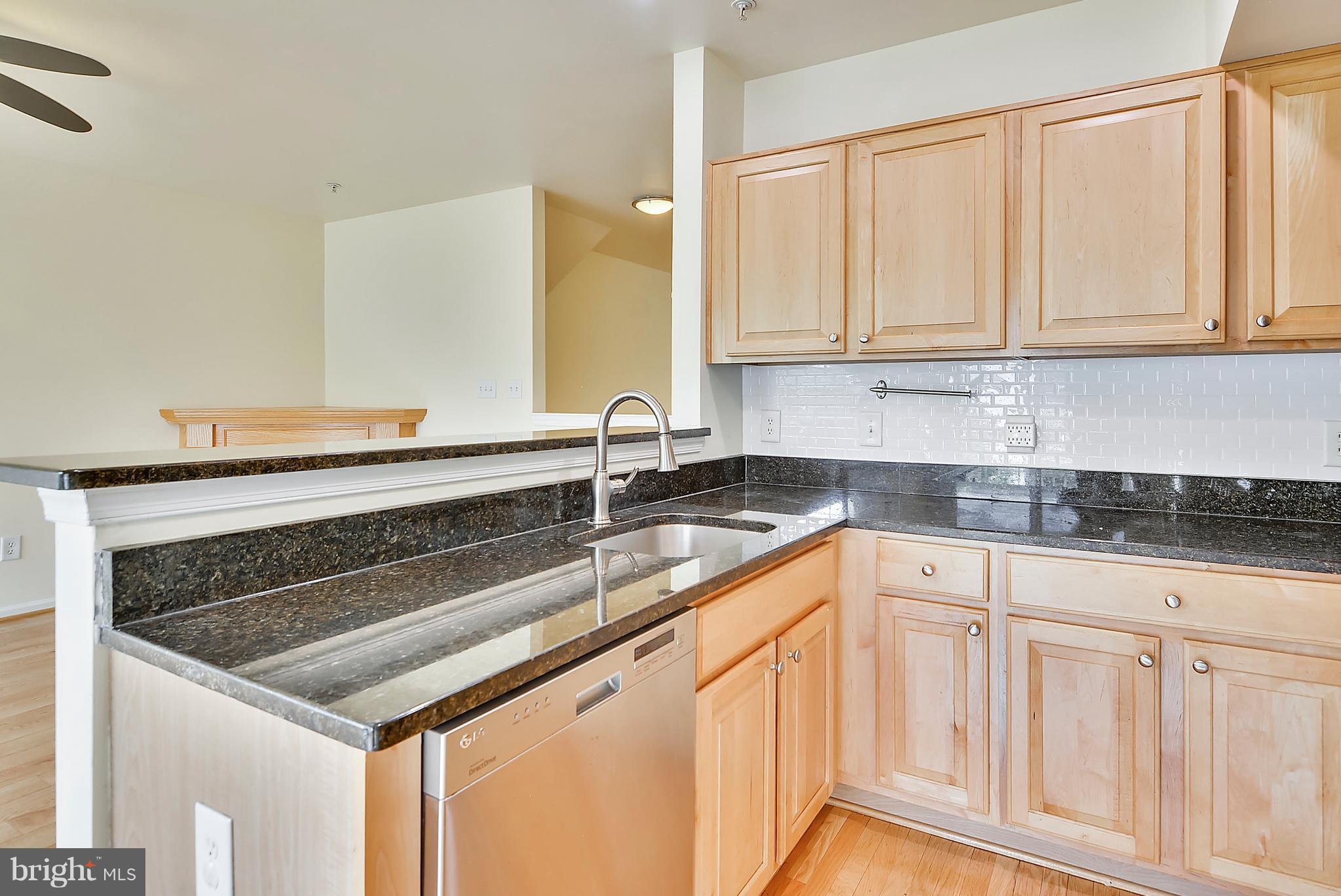 11357 King George Drive, Unit 10 Wheaton, MD 20902 - Photo 12 of 30 a kitchen with granite countertop white cabinets and a sink
