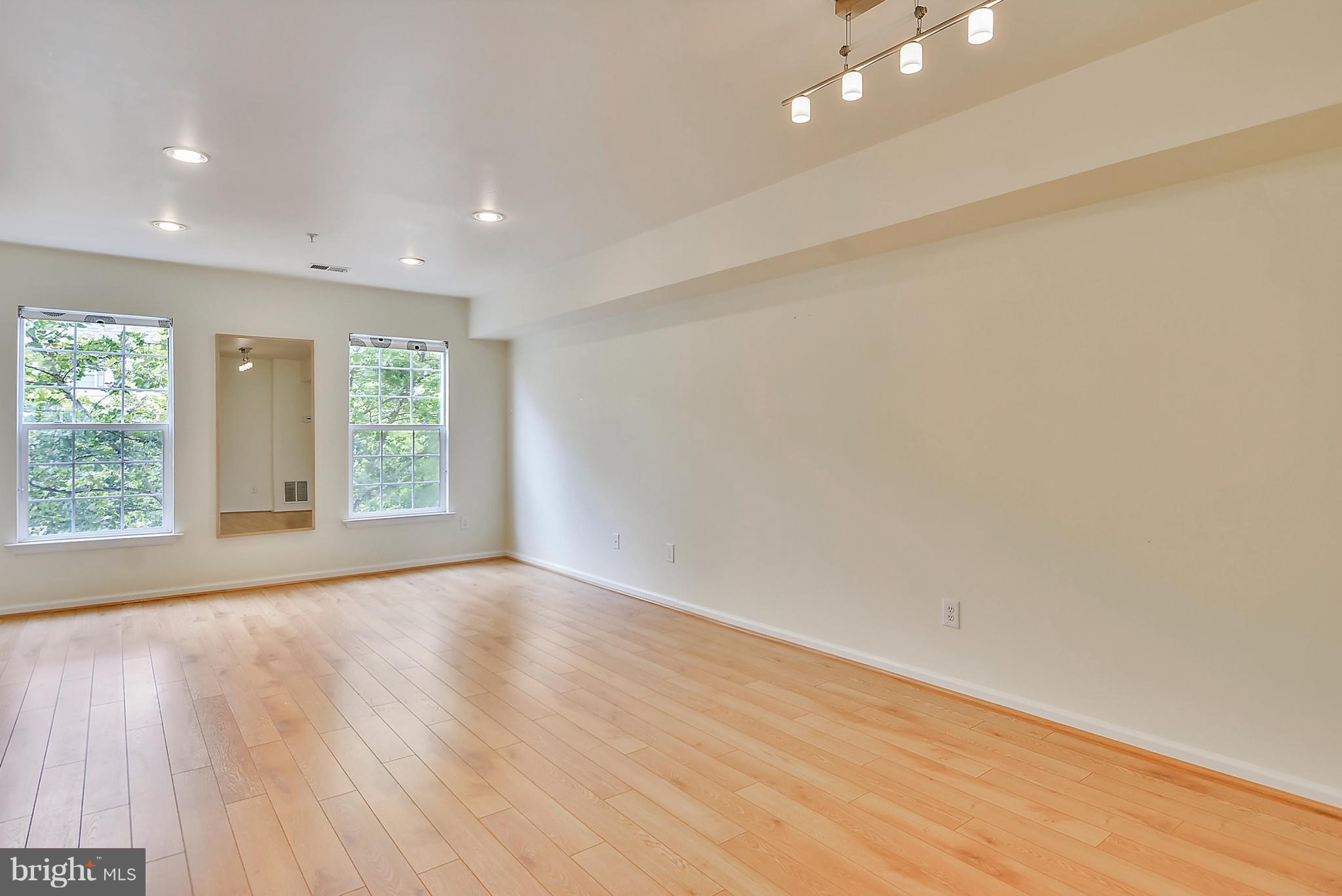 11357 King George Drive, Unit 10 Wheaton, MD 20902 - Photo 5 of 30 an empty room with wooden floor and windows