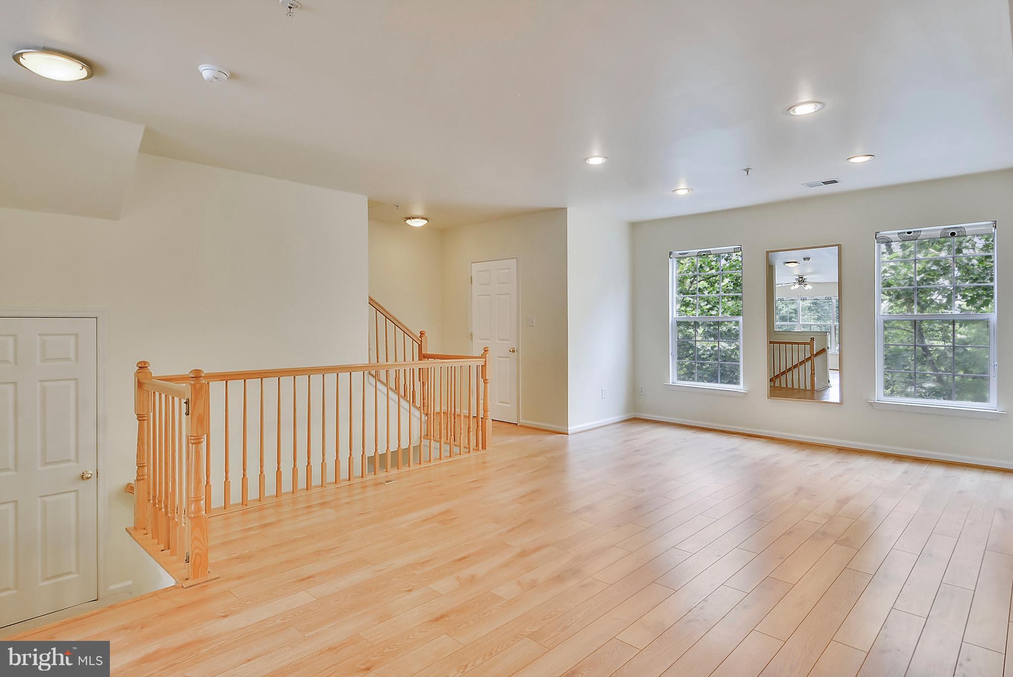 11357 King George Drive, Unit 10 Wheaton, MD 20902 - Photo 6 of 30 an empty room with wooden floor and windows