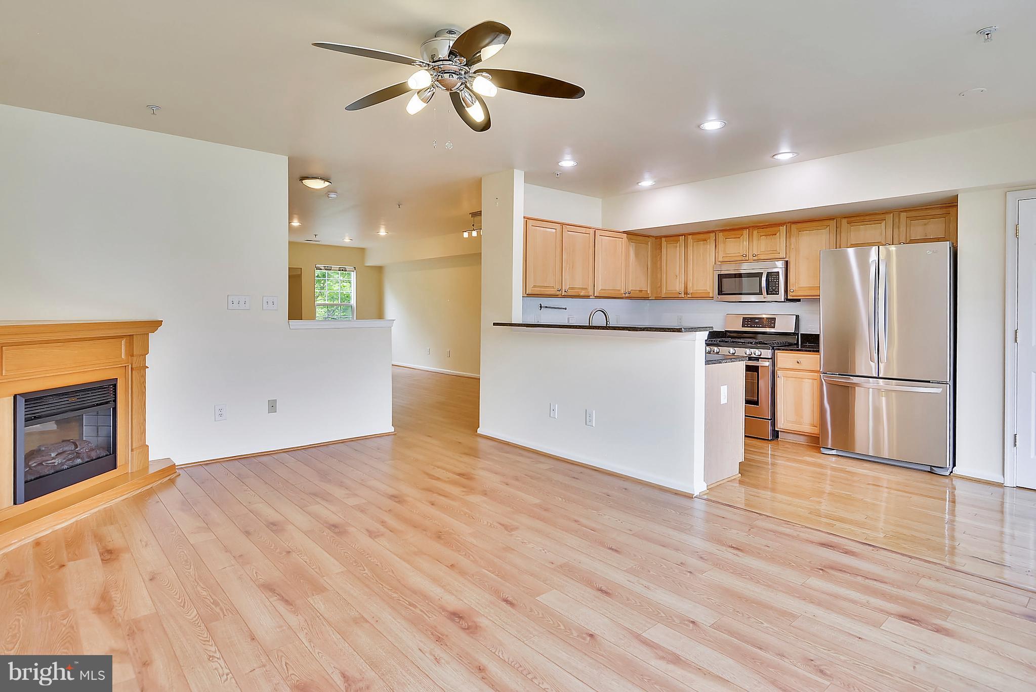 11357 King George Drive, Unit 10 Wheaton, MD 20902 - Photo 10 of 30 a view of a kitchen with a stove cabinets and wooden floor