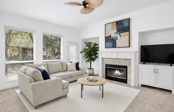 a living room with furniture a fireplace and a flat screen tv