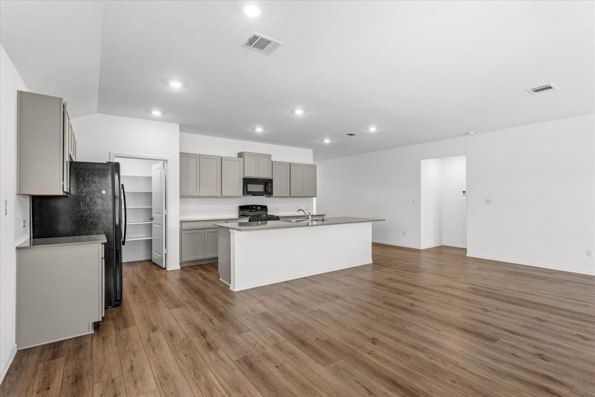167 Jeffers Kyle, TX 78640 - Photo 5 of 40 a kitchen with a refrigerator and a stove top oven