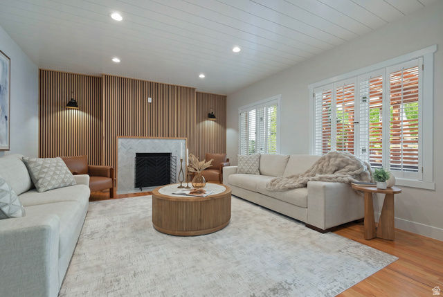 16 Gatehouse Lane Sandy, UT 84092 - Photo 17 of 73 Family room featuring wood accented walls, recessed lighting, a fireplace with flush hearth, light wood-style floors