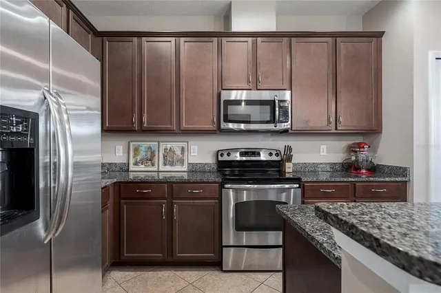 a kitchen with stainless steel appliances granite countertop a stove a refrigerator and a microwave