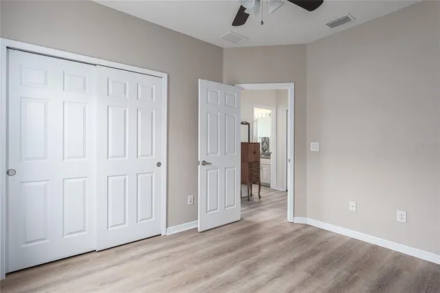 a view of a livingroom with wooden floor and a bathroom