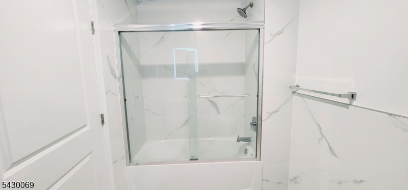 30 Howe Avenue, Unit 303 Passaic, NJ 07055 - Photo 8 of 11 a bathroom with a glass shower door