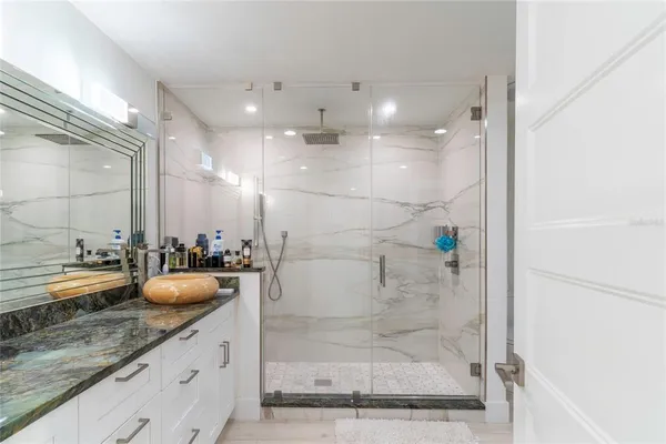 a bathroom with a granite countertop sink and a mirror
