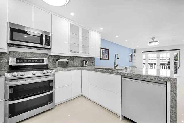 a kitchen with stainless steel appliances granite countertop a stove microwave and sink