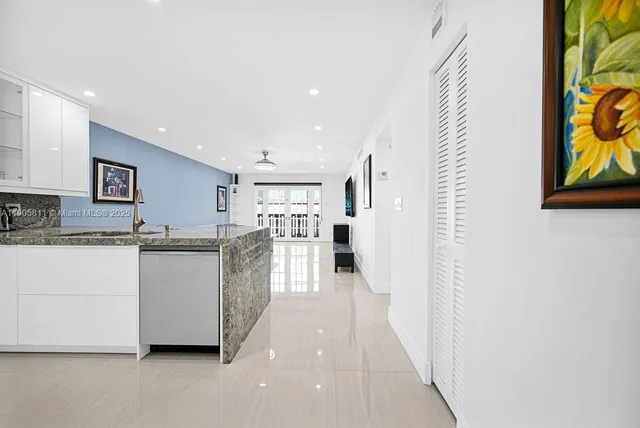 a large white kitchen with stainless steel appliances a large window
