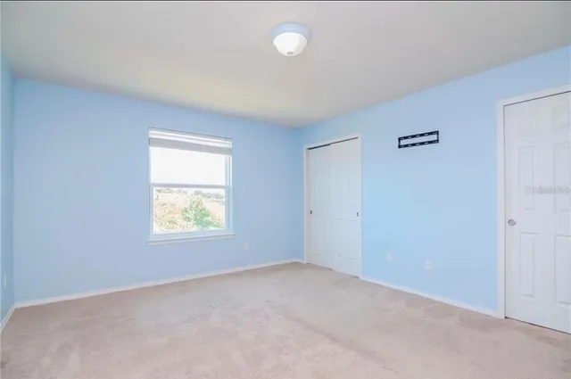 an empty room with windows and closet