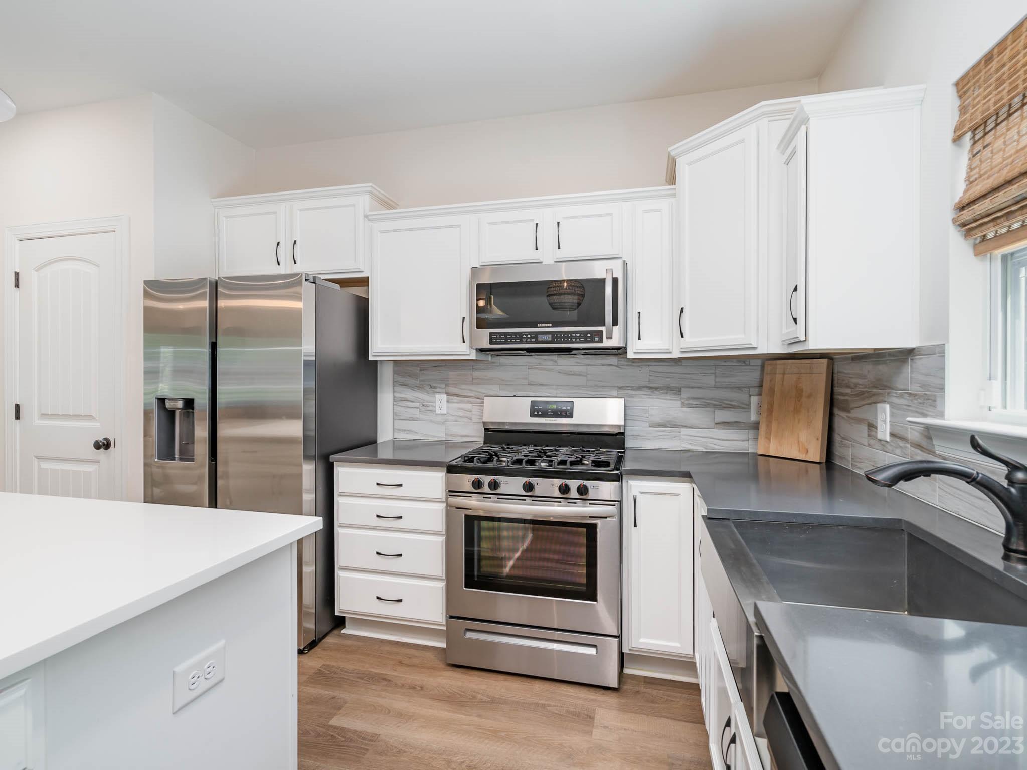 162 Niven Road Lancaster, SC 29720 - Photo 7 of 29 a kitchen with granite countertop a stove microwave and refrigerator