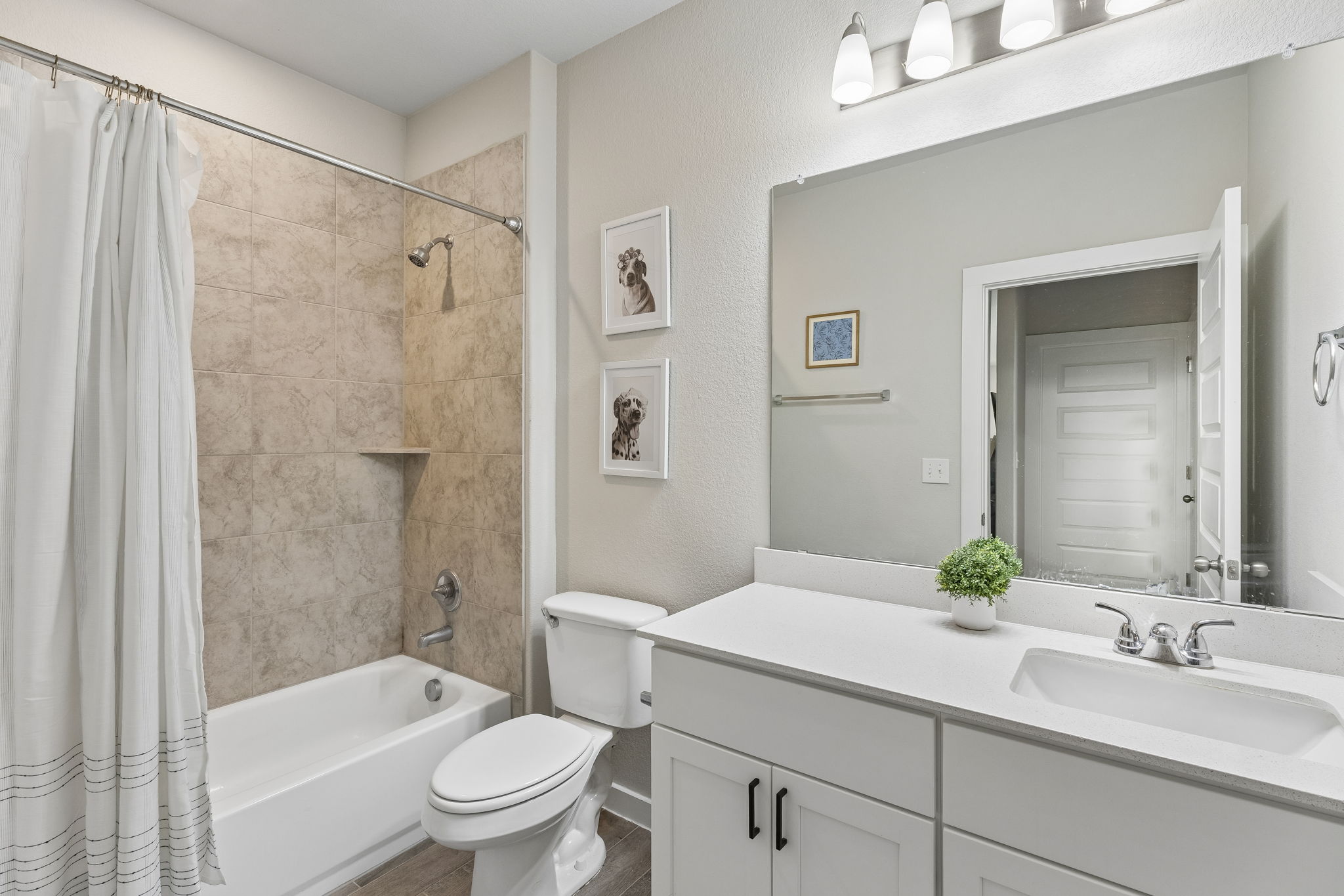 164 Appleberry Lane Elgin, TX 78621 - Photo 12 of 40 Tiled tub surrounds and a modern white vanity define this clean full bathroom.