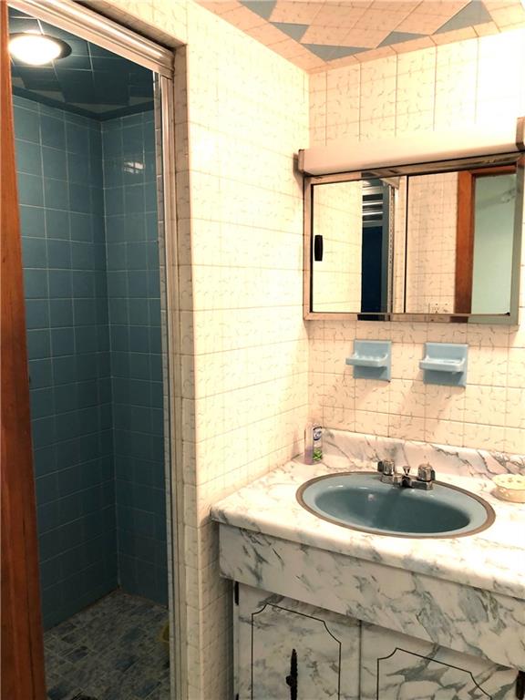 1063 64th Street Brooklyn, NY 11219 - Photo 14 of 20 a bathroom with a sink and a mirror