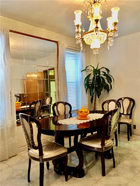1063 64th Street Brooklyn, NY 11219 - Photo 4 of 20 a view of a dining room with furniture and chandelier