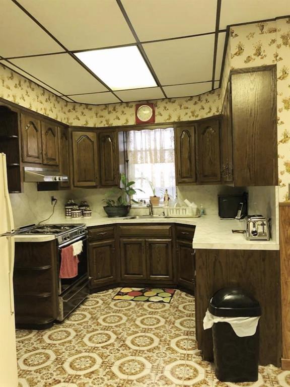 1063 64th Street Brooklyn, NY 11219 - Photo 8 of 20 a kitchen with stainless steel appliances granite countertop a sink and cabinets