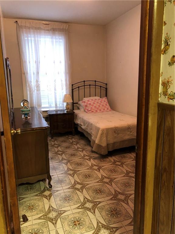 1063 64th Street Brooklyn, NY 11219 - Photo 10 of 20 a bedroom with a bed and wooden floor
