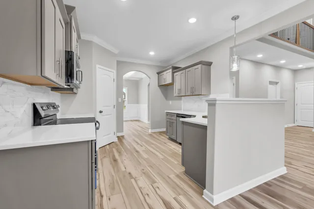 a large kitchen with stainless steel appliances a large counter top a stove and a refrigerator