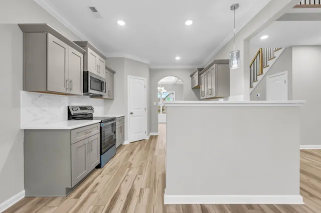 a kitchen with granite countertop a sink stove and cabinets