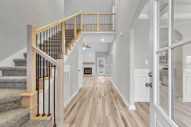 a view of a hallway with wooden floor and staircase