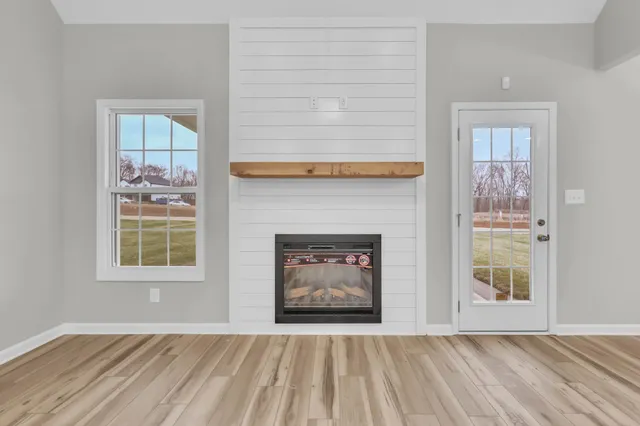 an empty room with windows and fireplace