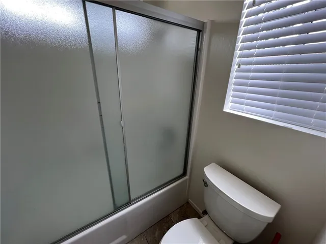 a white toilet sitting next to a shower