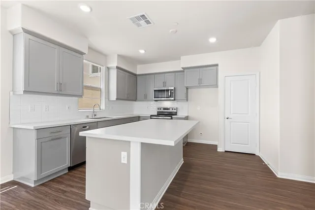 a kitchen with kitchen island a sink stainless steel appliances and cabinets