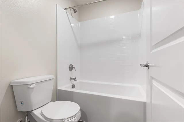 a white toilet and tub sitting next to a shower