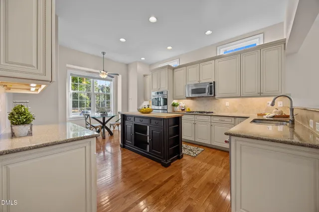 a kitchen with granite countertop a sink cabinets and stainless steel appliances