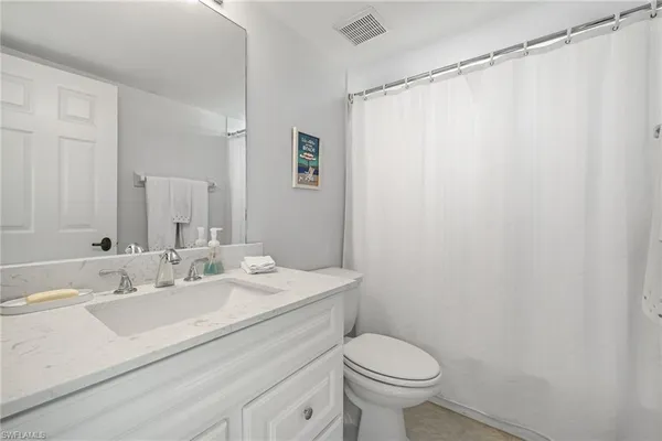 a bathroom with a sink a toilet and shower curtain