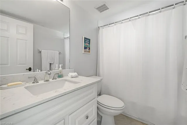 a bathroom with a sink a toilet and shower curtain